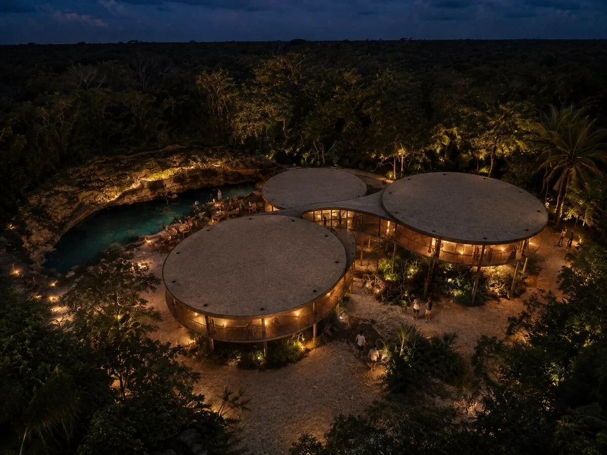 Pabellones iluminados junto a un cenote al anochecer